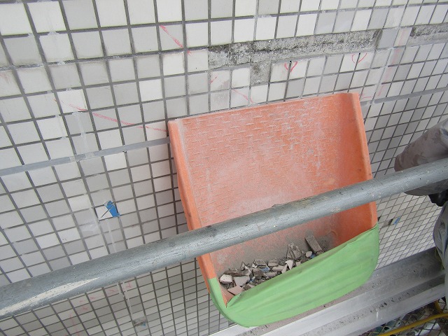 タイルを落とさないようちりとりで受ける